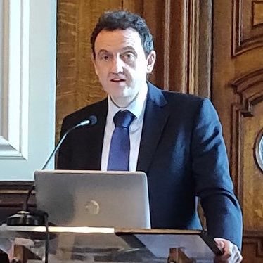 Colin Harvey speaking at a podium