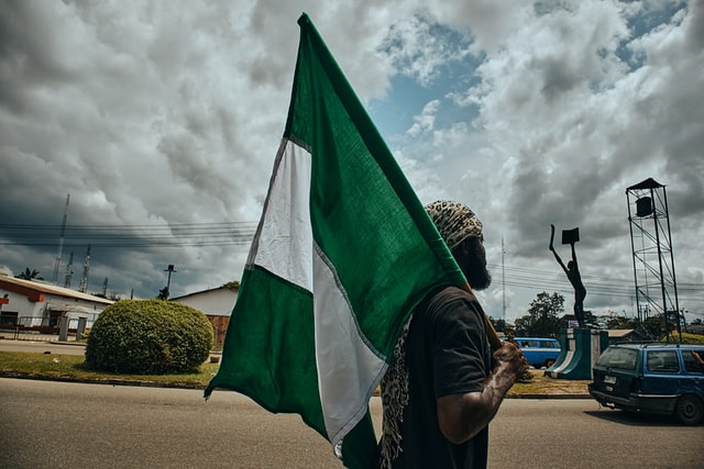 Protester walking with Nigeria flag