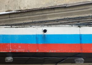 Camera mounted on side of building painted in colours of the Russian flag