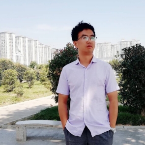 Chang Weiping is featured, wearing a white shirt, standing outside. A road is visible behind him with high rise apartments in the distance
