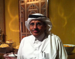 Mohammed Al Qatani is dressed in white, wearing glasses, and looks at the camera