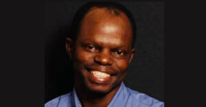 This is a portrait photograph of Thulani Maseko, looking at the camera and similing.