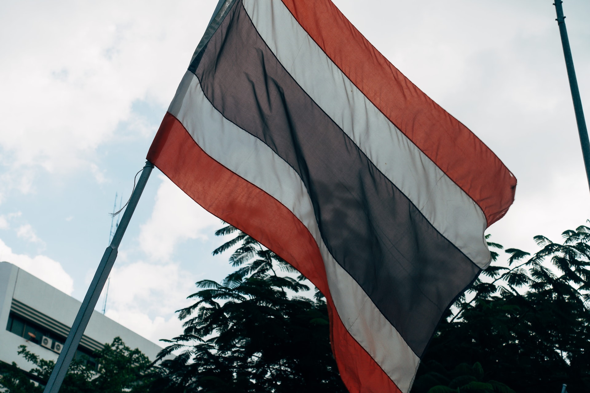 The flag of Thailand flying from the side of a building