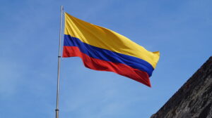 The flag of Colombia flying against a blue sky background.