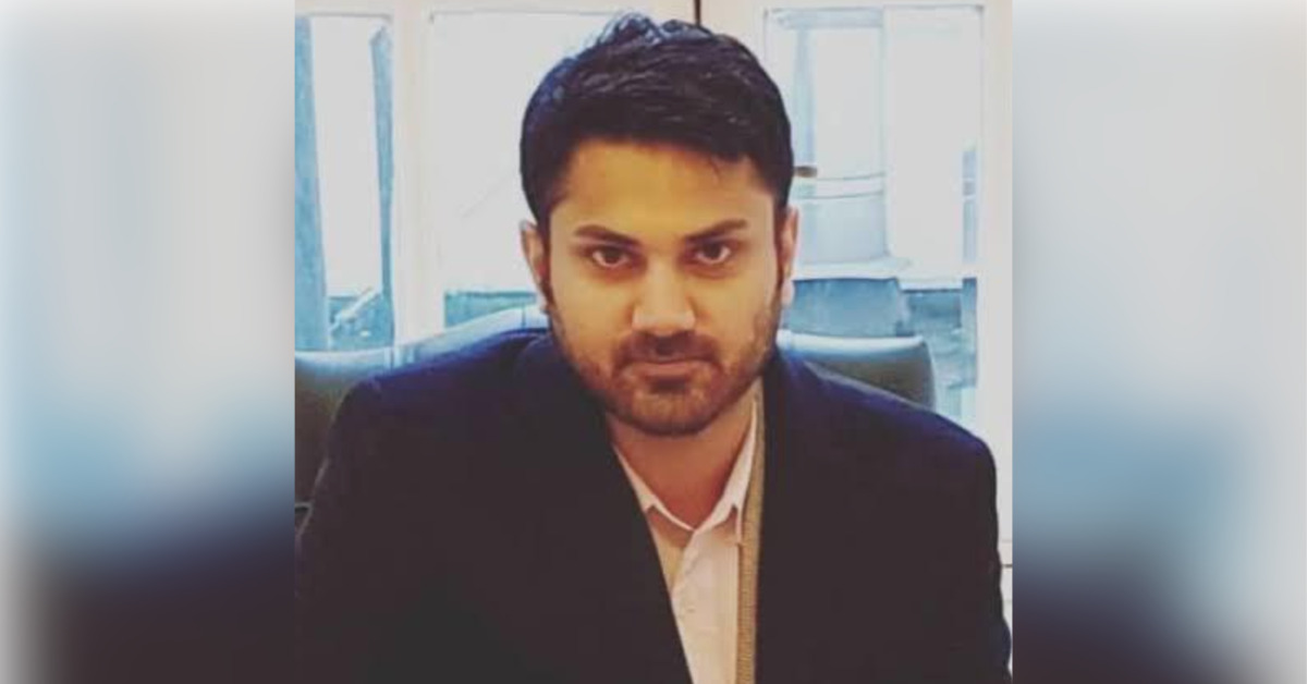 A close-up of Pakistani journalist Hamza Azhar Salam looking straight into the camera. He is wearing a black suit and white shirt.