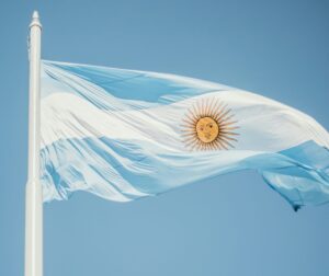 The flag of Argentina flying in the wind against a blue sky background.