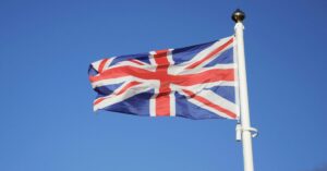 The Union Jack, flag of the United Kingdom of Great Britain and Northern Ireland, flying in the wind under the blue sky.