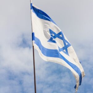 The flag of Israel blowing in the wind under a cloudy sky