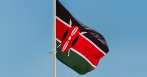 The flag of Kenya gently blowing in the wind under a blue sky