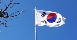 The flag of the Republic of Korea blowing in the wind under a blue sky.