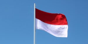 the flag of Indonesia flying against a blue sky