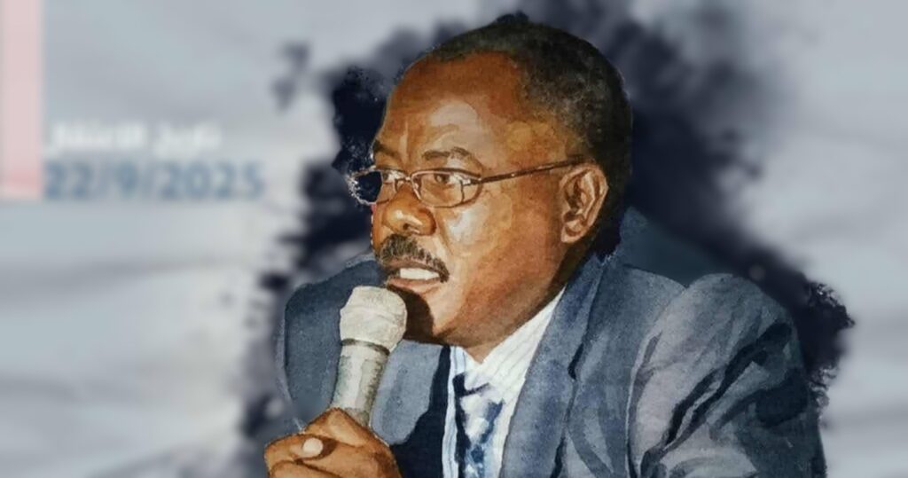 Sudanese human rights defender Abdelwahab Ahmed Mohamed Hashem speaking into a handheld microphone, wearing glasses and a dark suit. He is shown in profile, appearing focused and engaged while addressing an audience, with a blurred background.