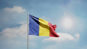 The Romanian flag blowing from a pole against a sunny sky